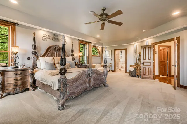a spacious bedroom with a large bed and a chandelier