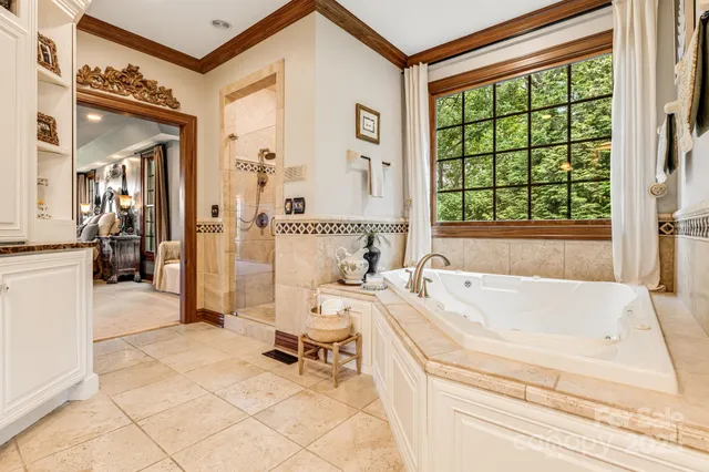 a spacious bathroom with a tub sink and mirror
