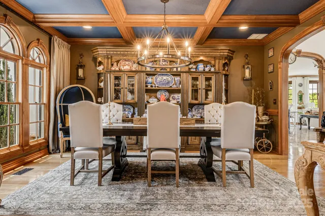a view of a dining room with furniture a chandelier and wooden floor