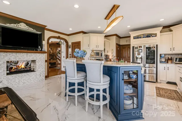 a kitchen with stainless steel appliances kitchen island granite countertop a refrigerator and microwave