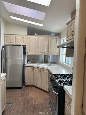 a kitchen with stainless steel appliances a stove and white cabinets