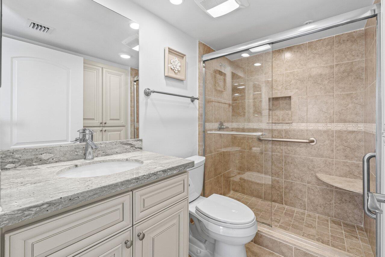 2707 North Ocean Boulevard, Unit 301D Boca Raton, FL 33431 - Photo 22 of 43 a bathroom with a granite countertop sink toilet and shower