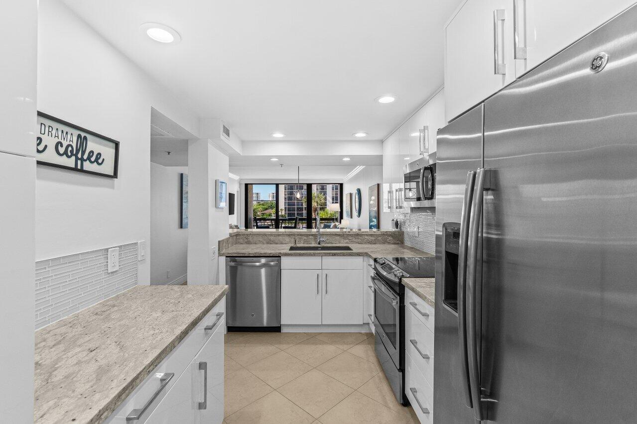 2707 North Ocean Boulevard, Unit 301D Boca Raton, FL 33431 - Photo 7 of 43 a kitchen with stainless steel appliances granite countertop a sink and a refrigerator