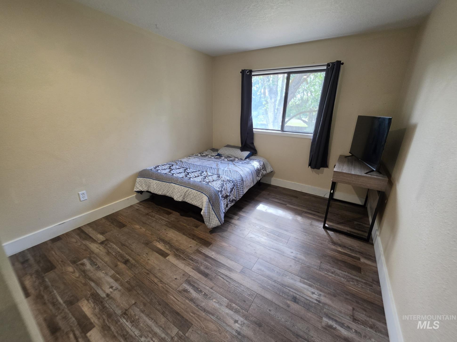 3201 South Riva Ridge Way Boise City, ID 83709 - Photo 15 of 29 Wood-finish flooring with white trim, a window with dark curtains, and light-toned walls