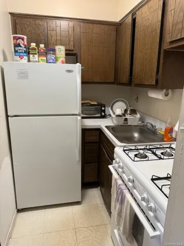 a white refrigerator freezer and a stove sitting inside of a kitchen