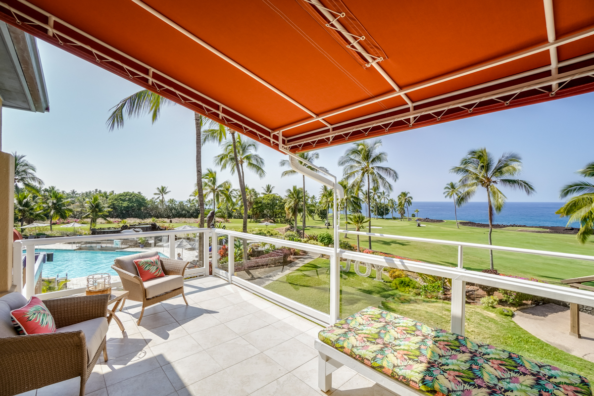 a view of swimming pool with a couches and chairs under an umbrella