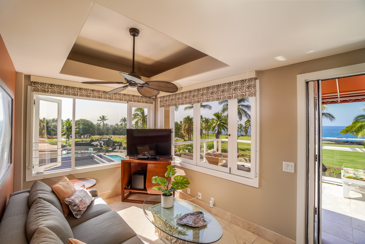 78-6834 Ali‘i Drive, Unit 22B 201 & 202 Kailua-Kona, HI 96740 - Photo 16 of 24 a living room with furniture a flat screen tv and a floor to ceiling window