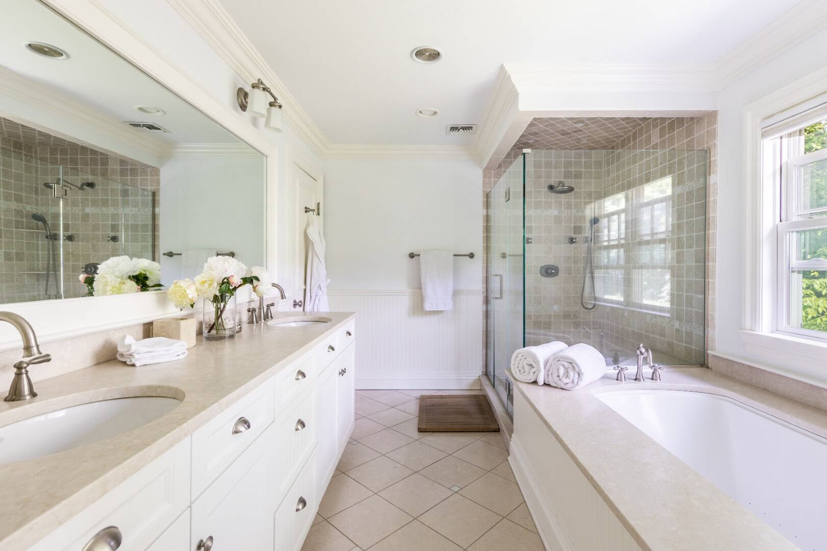 160 Ferry Road Sag Harbor, NY 11963 - Photo 17 of 25 a spacious bathroom with a double vanity sink a large mirror a bathtub and shower