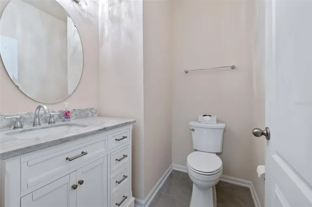 a bathroom with a granite countertop toilet sink mirror and vanity