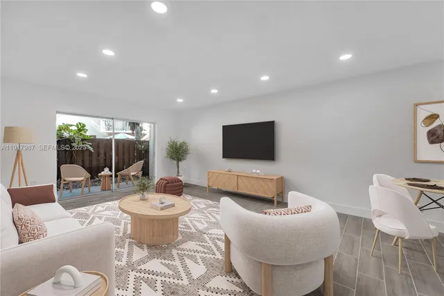 a living room with furniture a flat screen tv and a table