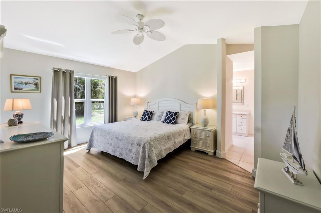 15350 Wimborne Lane, Unit 2 Naples, FL 34110 - Photo 18 of 42 a bedroom with a bed and a flat screen tv