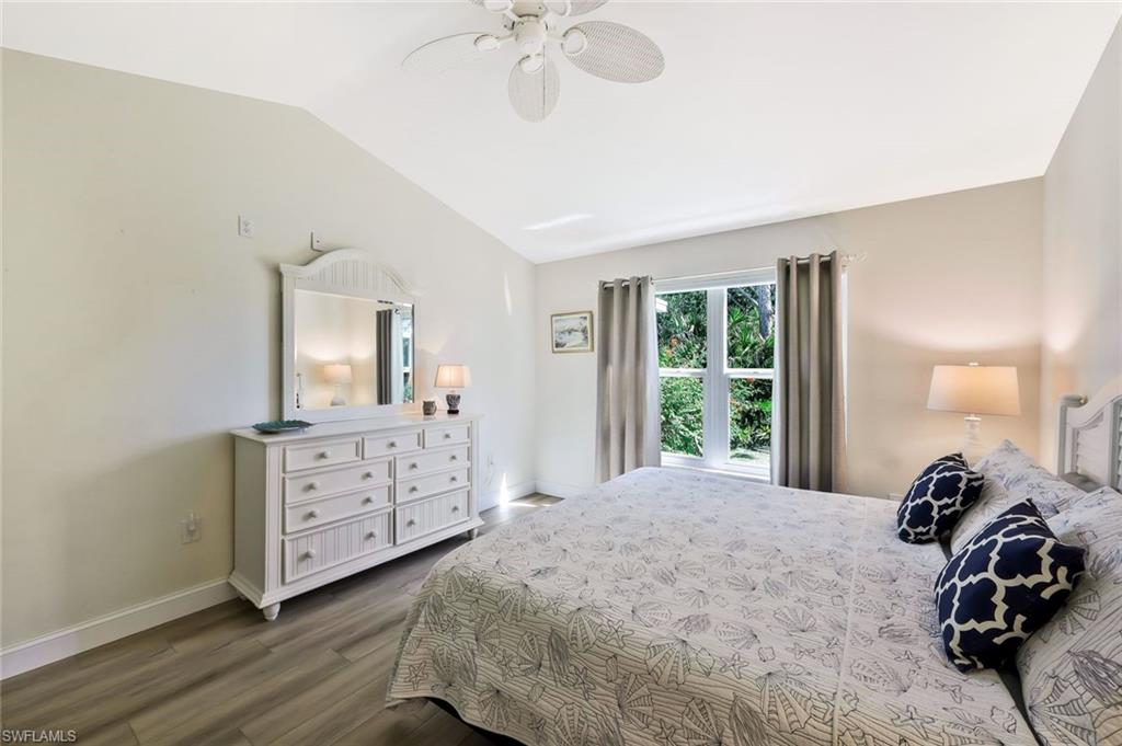 15350 Wimborne Lane, Unit 2 Naples, FL 34110 - Photo 19 of 42 a bedroom with a bed and a chandelier