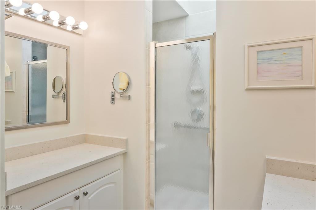 15350 Wimborne Lane, Unit 2 Naples, FL 34110 - Photo 22 of 42 a bathroom with a shower sink and mirror