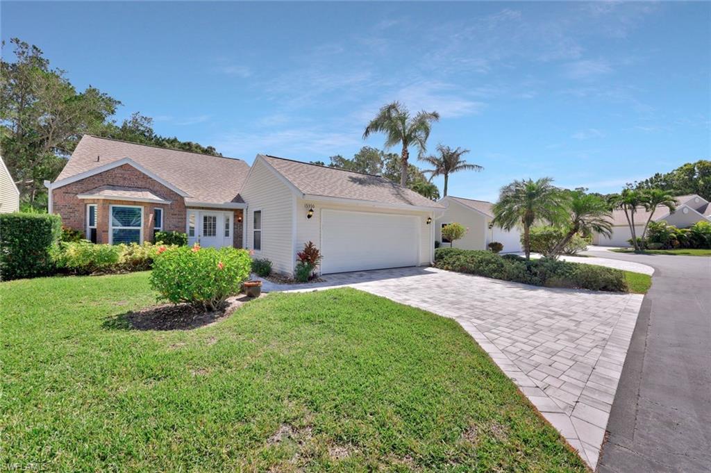 15350 Wimborne Lane, Unit 2 Naples, FL 34110 - Photo 3 of 42 a front view of a house with a yard and trees