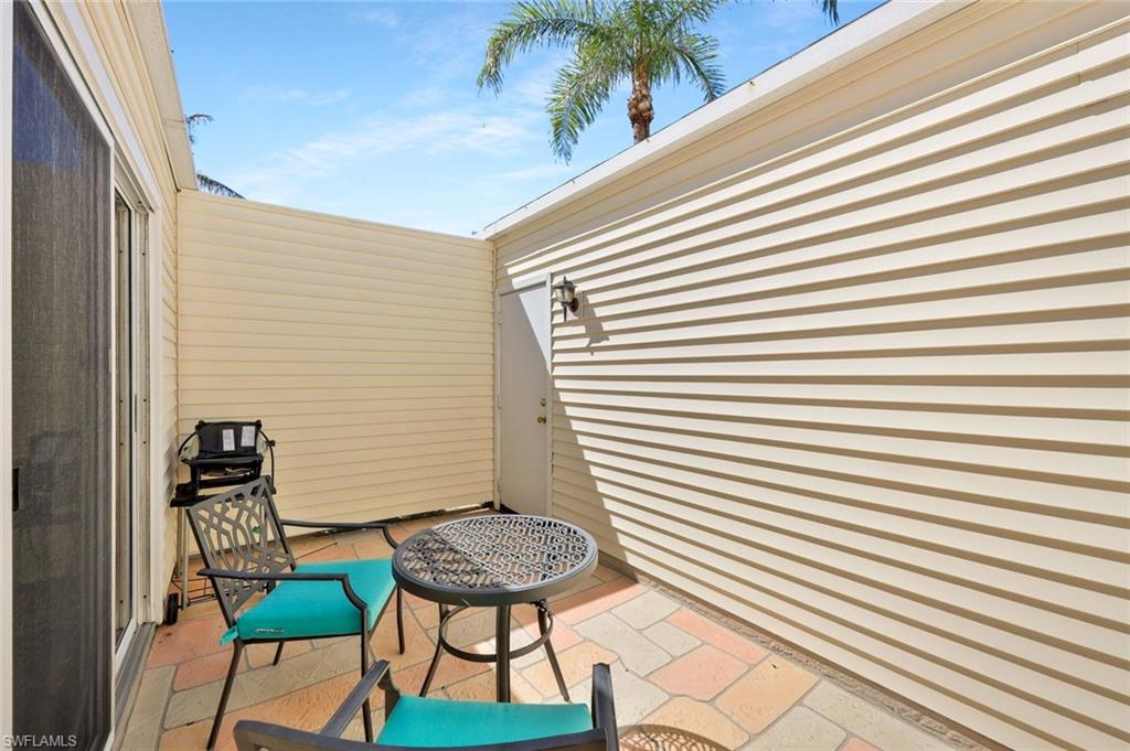 15350 Wimborne Lane, Unit 2 Naples, FL 34110 - Photo 32 of 42 a backyard of a house with table and chairs