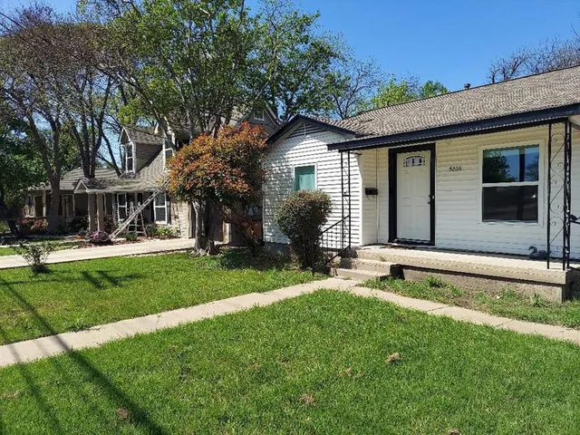 a view of a house with a yard patio and a small yard