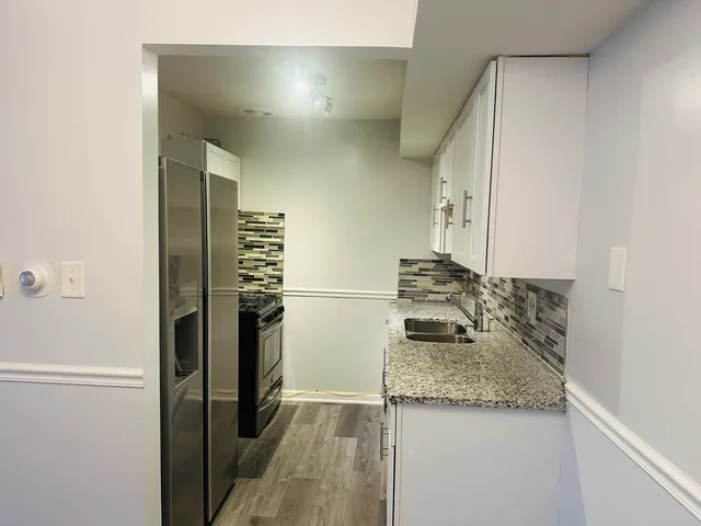 a kitchen with a granite countertop refrigerator and a sink