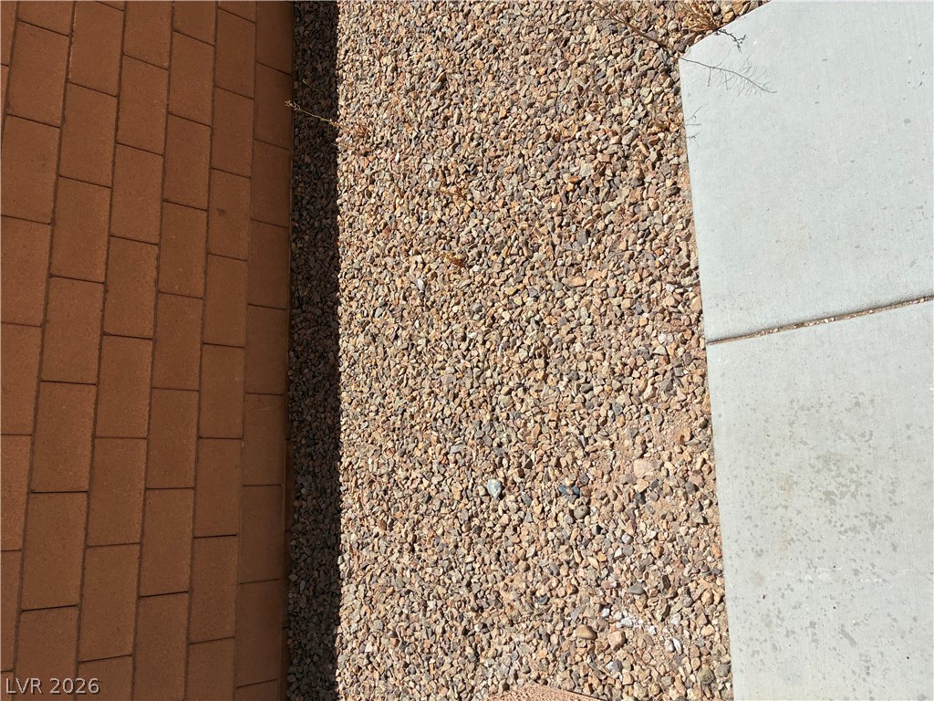 7727 Pista Way Las Vegas, NV 89179 - Photo 5 of 12 Gravel landscaping and paver walkway define the exterior.
