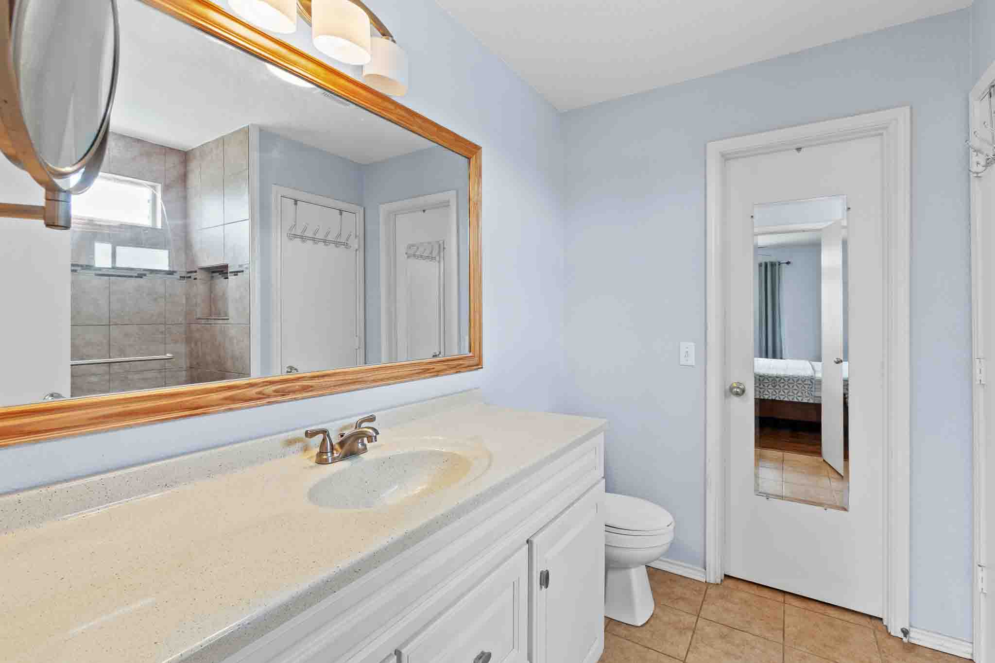 270 Endeavour Kyle, TX 78640 - Photo 12 of 20 Bathroom featuring a vanity with a light-colored countertop and integrated sink, a large framed mirror with overhead lighting, and tiled flooring