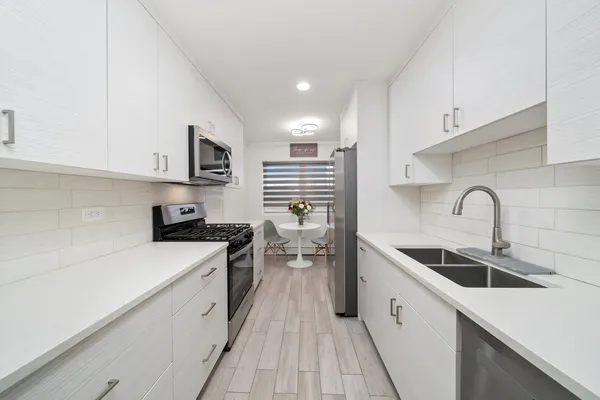 a kitchen with sink a stove and cabinets