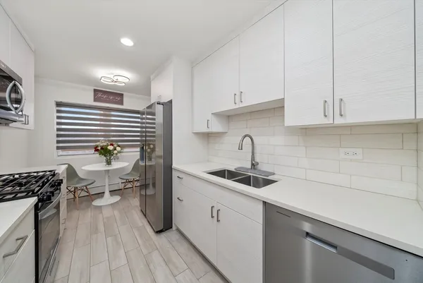 a kitchen with a sink a stove and cabinets