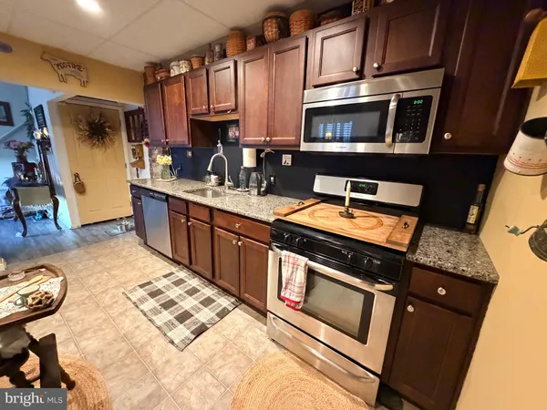 a kitchen with stainless steel appliances granite countertop a stove a sink and a microwave