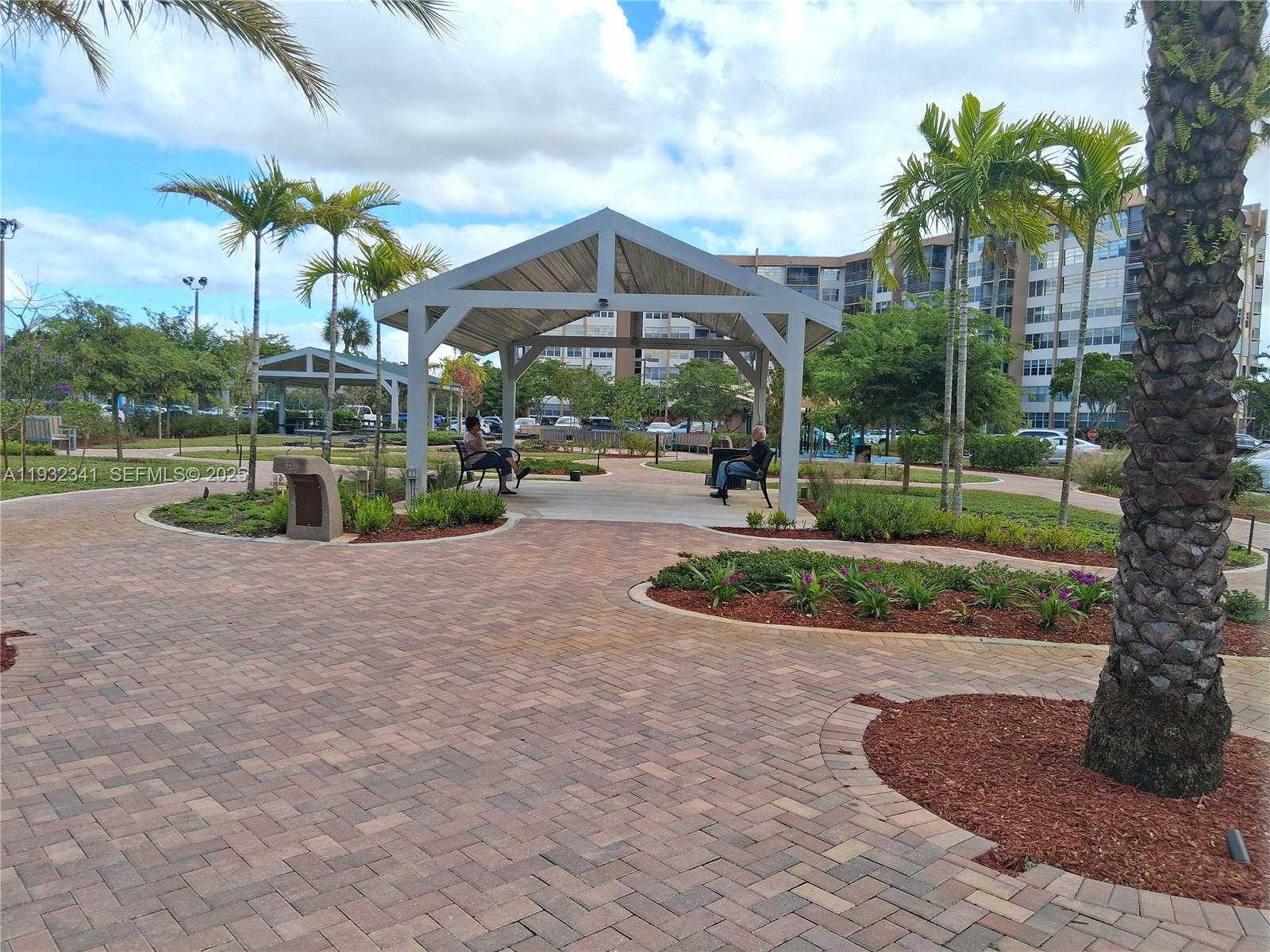 1000 St Charles Place, Unit L2 Pembroke Pines, FL 33026 - Photo 13 of 16 a view of a house with a yard and potted plants