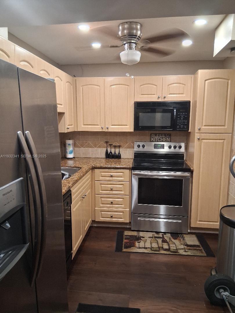 1000 St Charles Place, Unit L2 Pembroke Pines, FL 33026 - Photo 3 of 16 a kitchen with stainless steel appliances a stove a microwave and a refrigerator