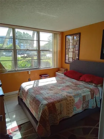 a room with a bed and a painting on the wall