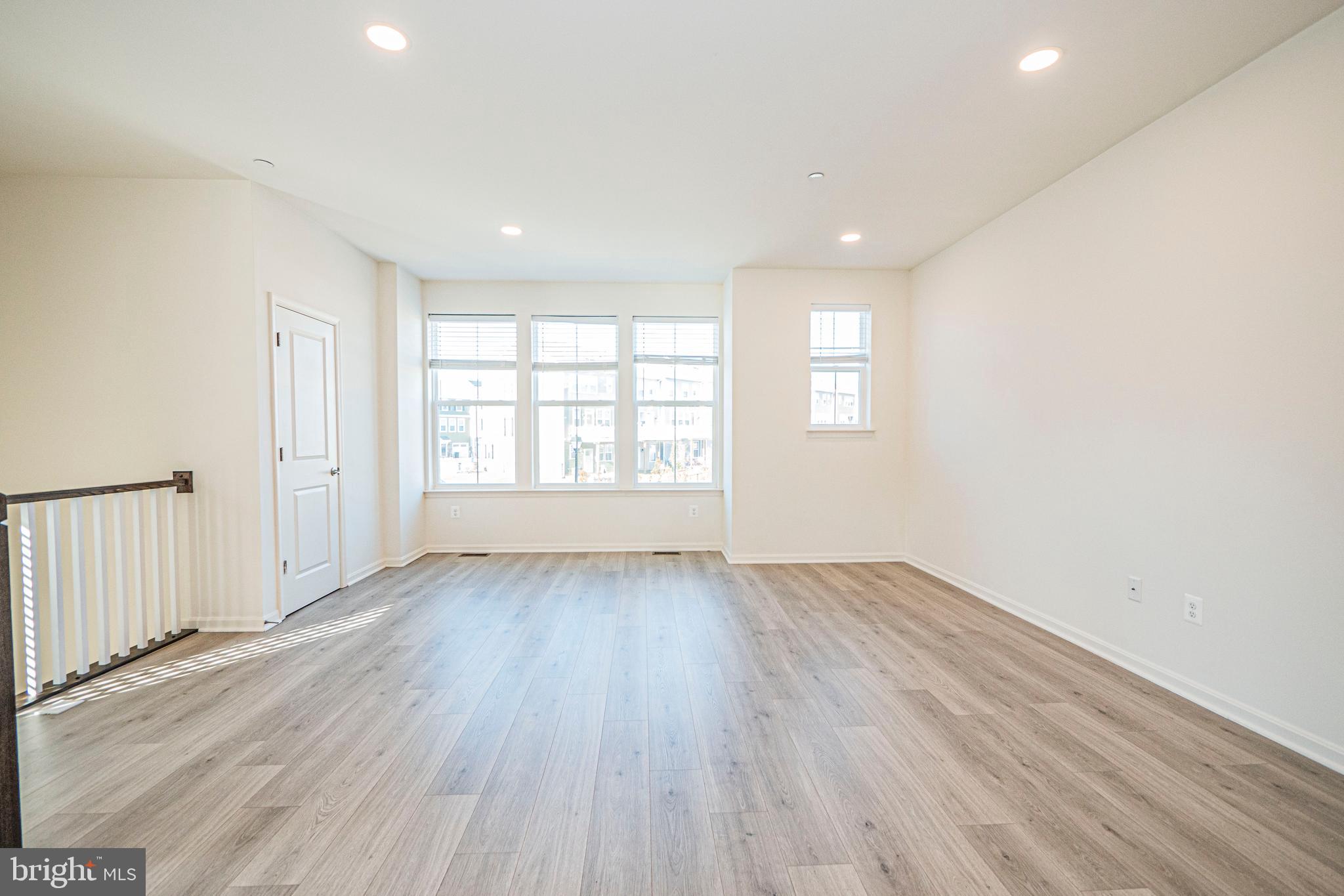 7315 Martin Farm Circle Rosedale, MD 21237 - Photo 14 of 46 an empty room with wooden floor and windows