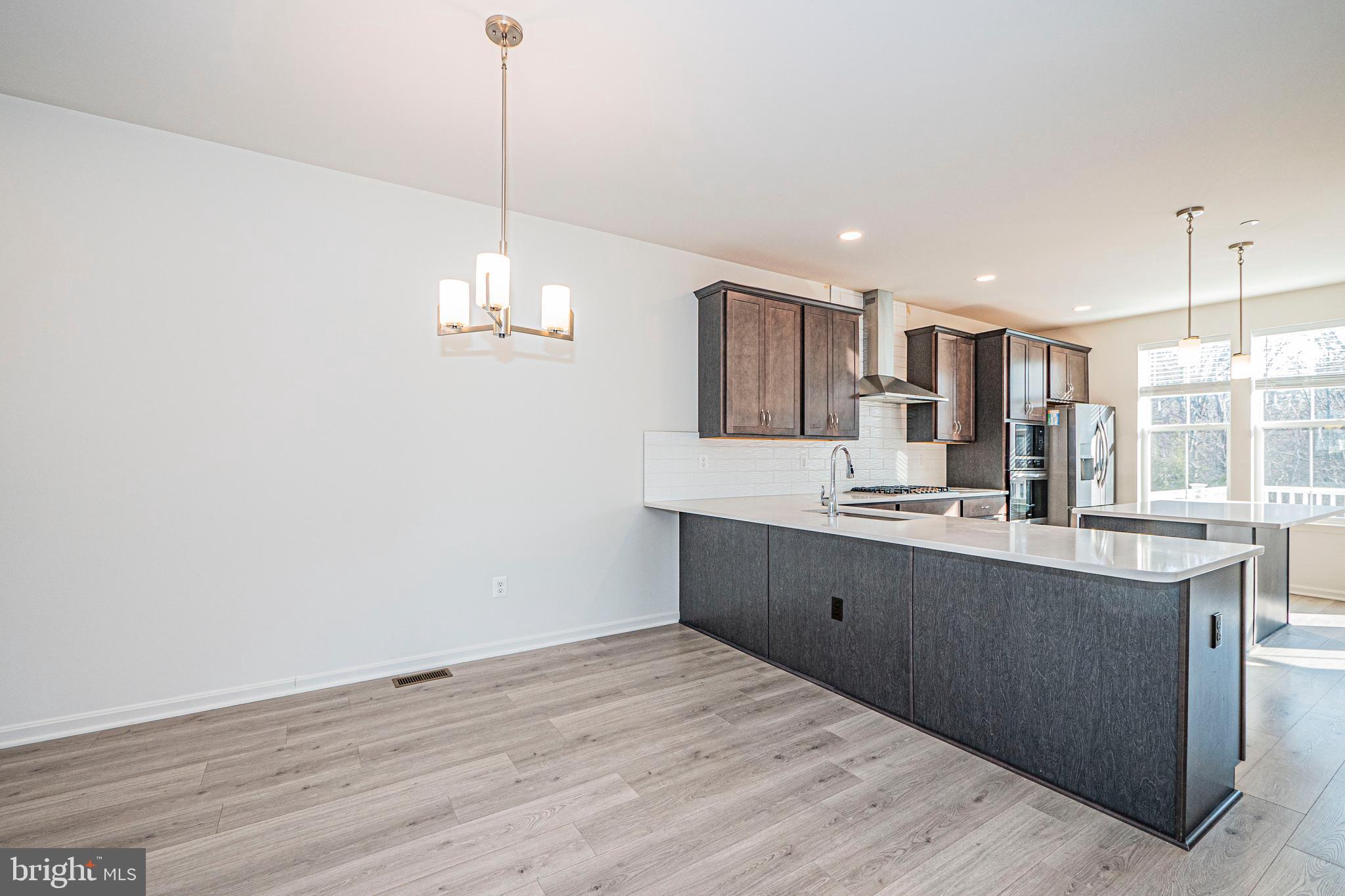 7315 Martin Farm Circle Rosedale, MD 21237 - Photo 24 of 46 a open kitchen with kitchen island a sink dishwasher a refrigerator and wooden floor