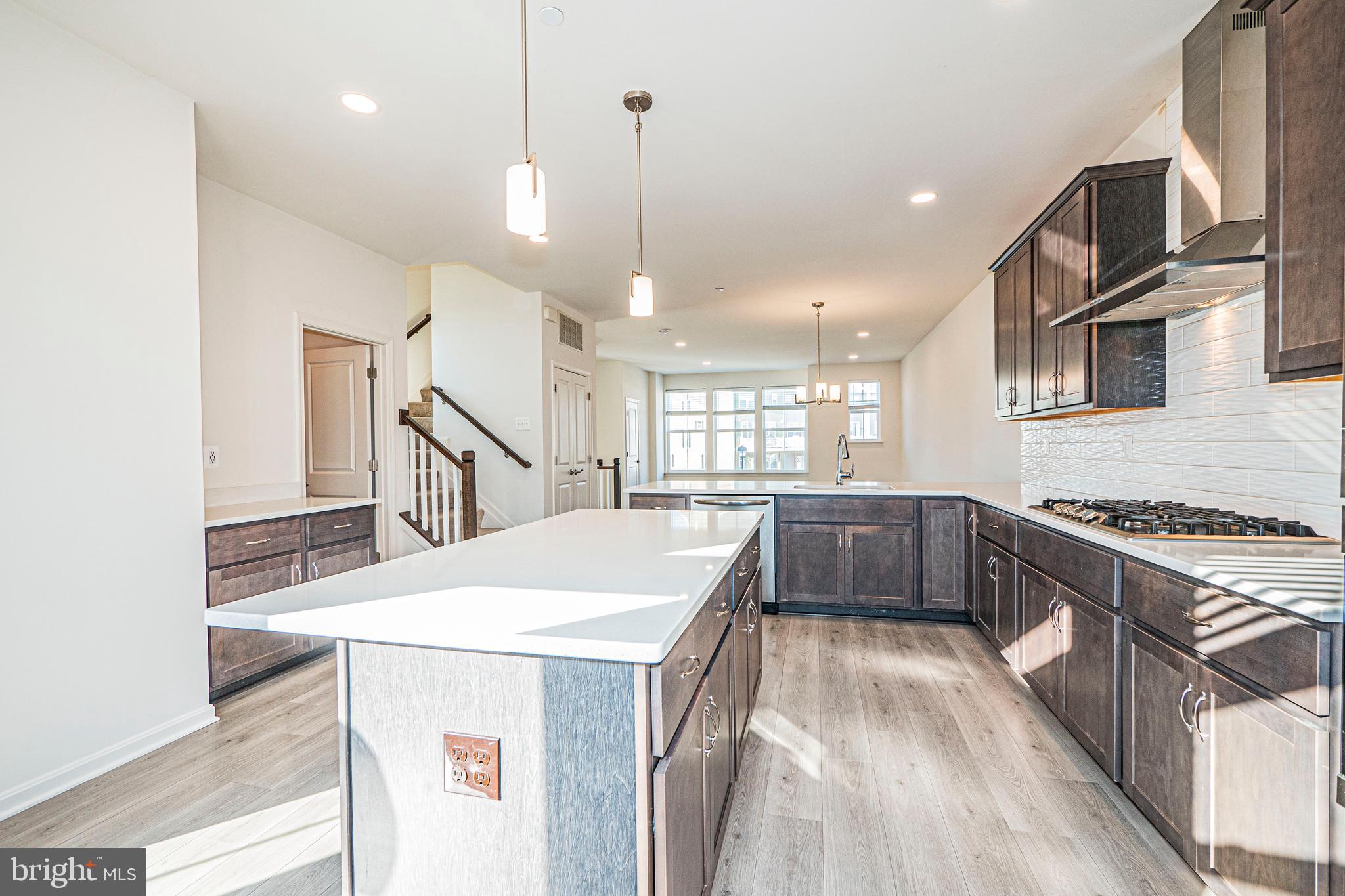 7315 Martin Farm Circle Rosedale, MD 21237 - Photo 26 of 46 a kitchen with kitchen island a stove a sink a center island and wooden floor