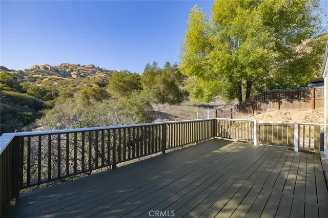a view of a balcony with wooden floor and fence
