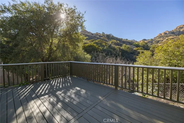 a view of balcony with wooden floor and fence