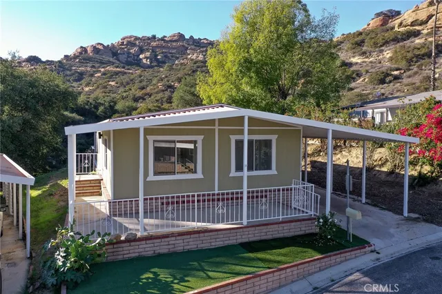 a view of a house with a small yard and wooden floor and fence