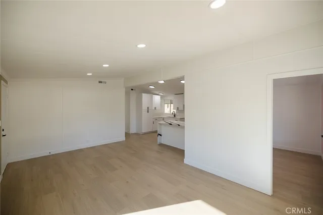 a view of a big room with wooden floor and a window