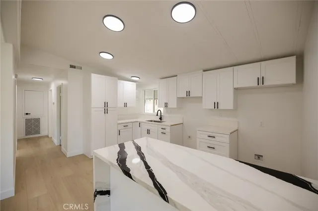 a open kitchen with white cabinets and stainless steel appliances