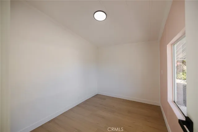 a view of a room that has wooden floor and window