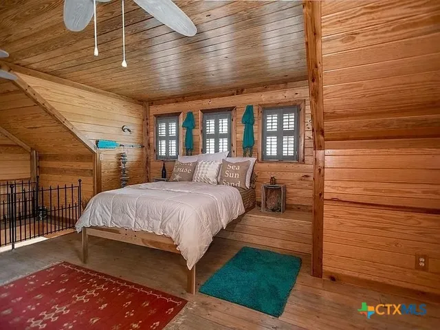 a large bedroom with a bed and wooden floor