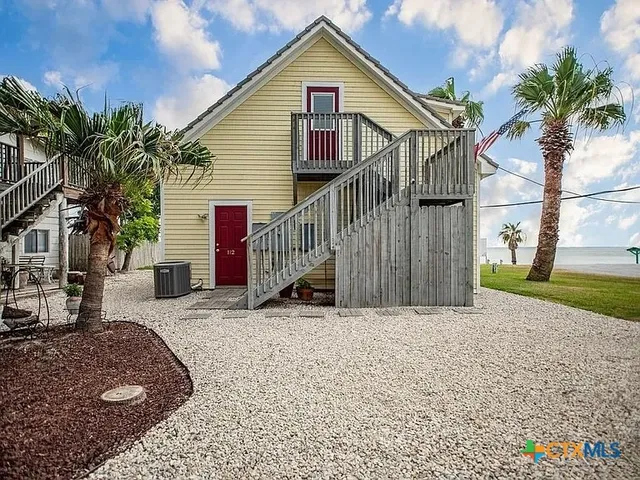 a view of a house with a yard and potted plants