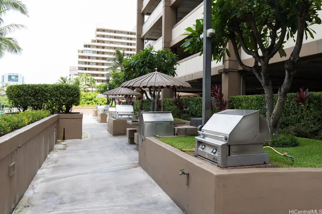 a view of a patio with couches table and chairs with wooden fence and plants