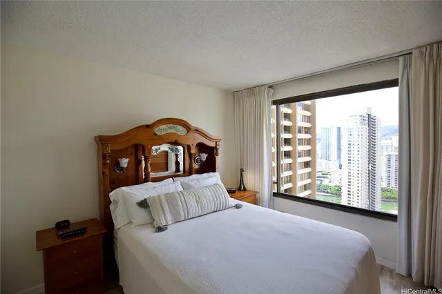 a bedroom with a bed and a large window