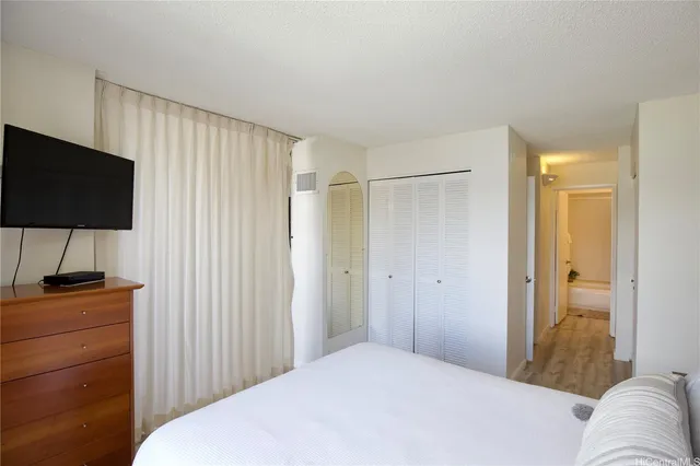 a bedroom with a bed and a flat screen tv