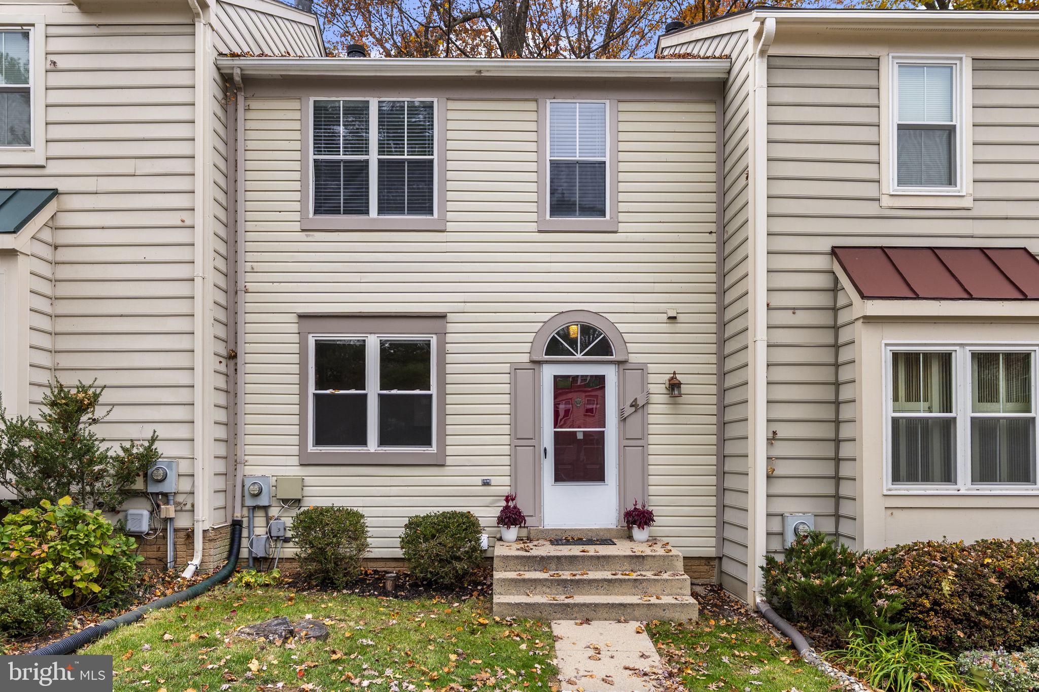 4 Waterside Court Germantown, MD 20874 - Photo 1 of 37 a brick house with a large windows and flower plants