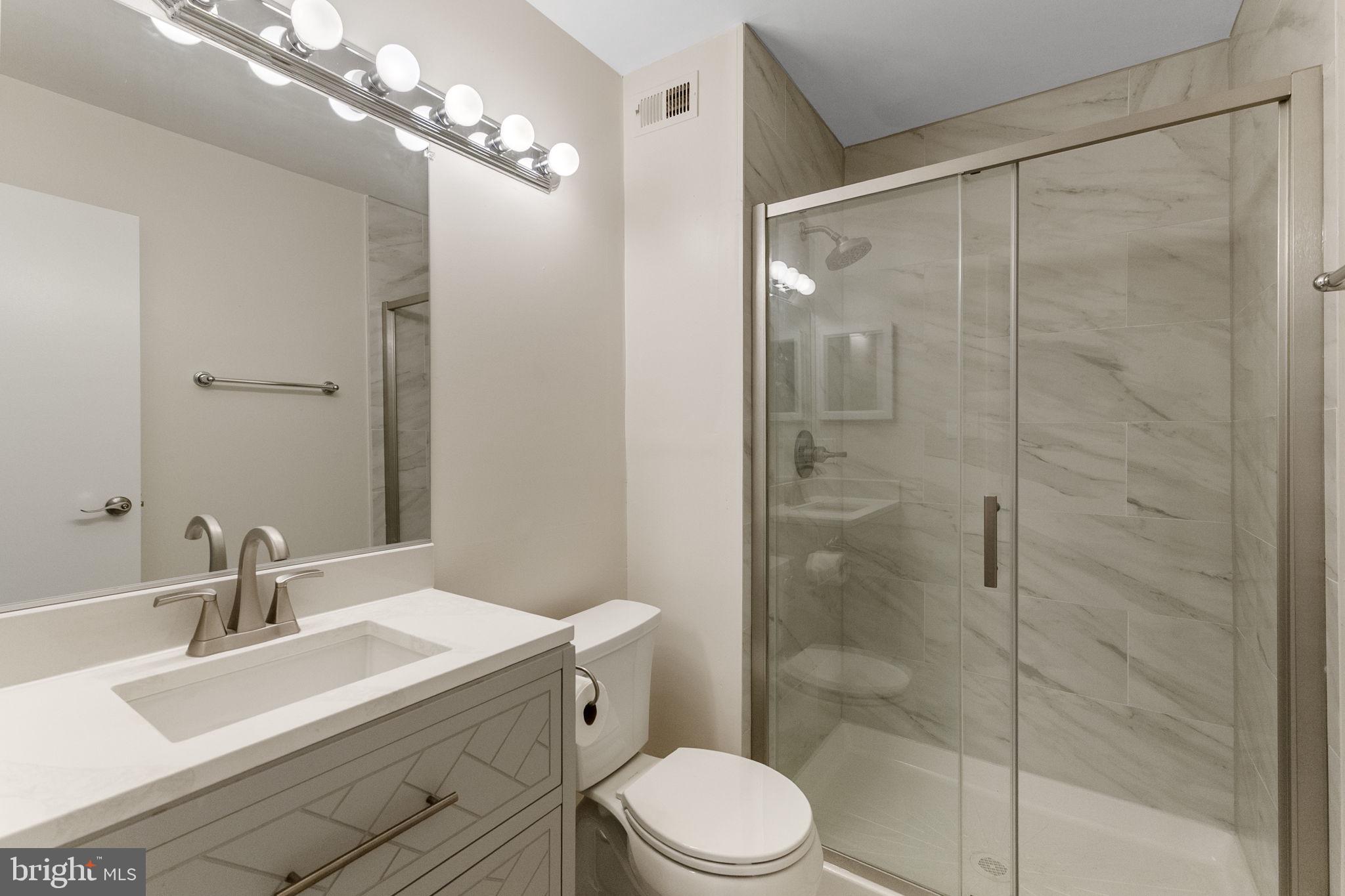 4 Waterside Court Germantown, MD 20874 - Photo 28 of 37 a bathroom with a sink toilet a mirror and shower