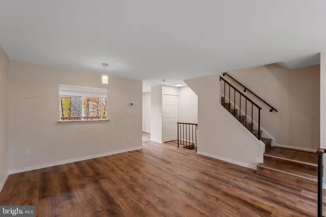 a view of a room with wooden floor and white walls