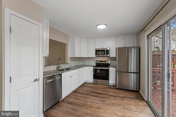 a kitchen with cabinets stainless steel appliances and a window