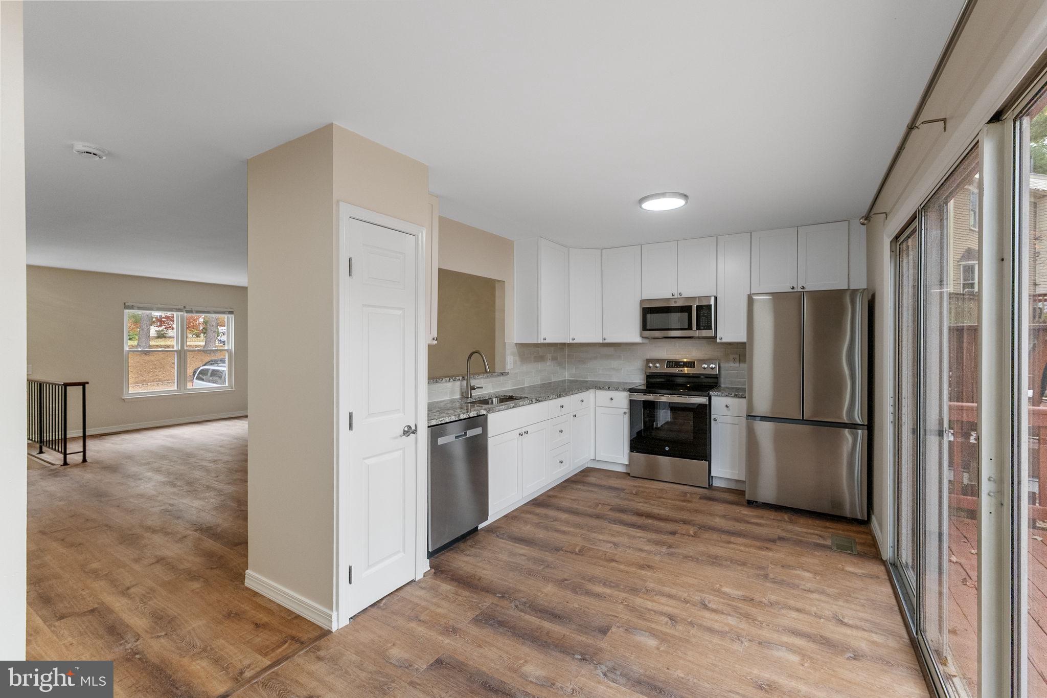 4 Waterside Court Germantown, MD 20874 - Photo 8 of 37 a kitchen with a refrigerator a stove top oven and kitchen island