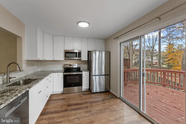 a kitchen with stainless steel appliances granite countertop a refrigerator stove and sink