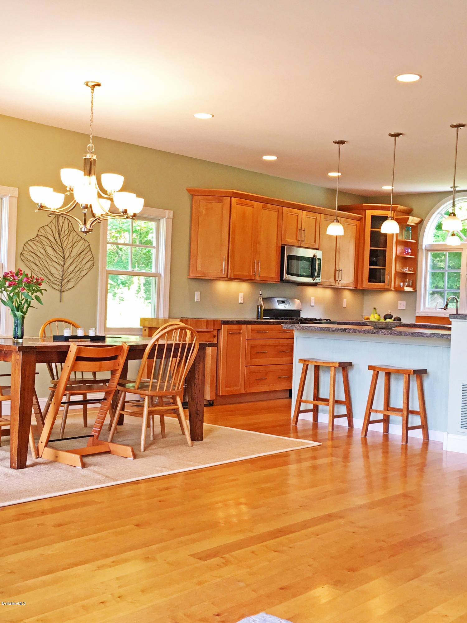 93 Stebbins Road Otis, MA 01253 - Photo 12 of 41 a open kitchen with stainless steel appliances granite countertop a stove top oven a dining table and chairs with wooden floor